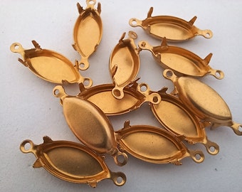 May include: A collection of gold-colored, oval-shaped jewelry findings. Each finding has a shallow dish, small loops on each end, and prongs for securing a stone or other element. These components are likely for creating necklaces, bracelets, or earrings.