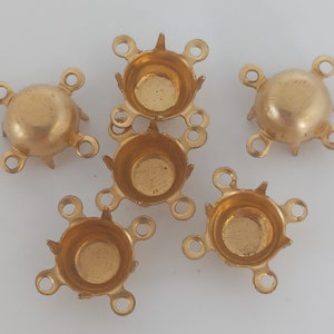May include: Five gold-toned metal settings for attaching rhinestones or other embellishments. Each setting has four prongs and four loops for attaching to a project.