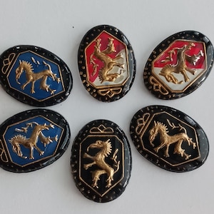 May include: Six oval-shaped, black-rimmed buttons with gold-colored, stylized dragon designs. Each button has a different colored background: red, white, blue, and black.