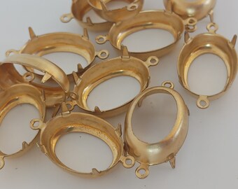 Puede incluir: Un grupo de engastes metálicos ovalados de color dorado con puntas en la parte inferior y bucles en los lados.