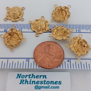 May include: Six gold-tone metal rose flower charms with four jump rings each. The charms are approximately the size of a UK penny.