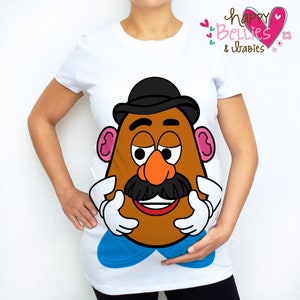 May include: White t-shirt featuring a cartoon Mr. Potato Head design. The graphic includes a brown potato head with a black hat, mustache, and orange nose. The shirt has the text "Happy Bellies & Babies" in pink and green.