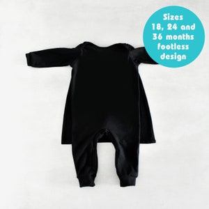 May include: Black long-sleeve footed sleeper with a cape back. Sizes 18, 24 and 36 months. Footless design.