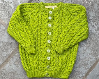 Barnkofta i Aran-stil. Ålder 5-6 khaki limegrön. Handstickad i Storbritannien