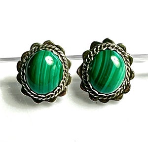 May include: A pair of silver earrings with green malachite stones set in a decorative silver frame.