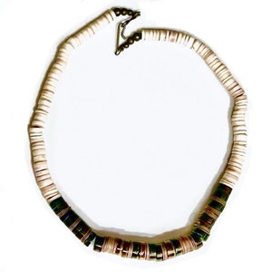 May include: A white and green beaded necklace with a brass clasp. The necklace is made of round, flat beads.