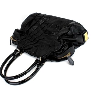 Puede incluir: Bolso de mano de cuero negro con un dise&ntilde;o plisado texturizado. Cuenta con dos asas negras brillantes y cremalleras doradas. Un acento rectangular dorado est&aacute; en el lateral. La bolsa est&aacute; sobre un fondo blanco.