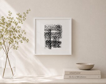 May include: A framed abstract art print with a white border. The artwork features a black and white textured design. The print is displayed on a neutral-toned surface, alongside a small bowl and books.