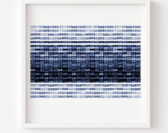 May include: A square framed wall art piece featuring a horizontal pattern of small, hand-painted blue and white watercolor squares. The design consists of alternating rows of light and dark indigo shades, creating a textured, grid-like appearance.