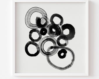 May include: A square art print featuring a collection of black ink circles on a white background. The circles vary in size and thickness, with some displaying visible brushstroke textures and layered line work. The text at the bottom reads: ** Print comes Unframed (no frame or matt included) **.