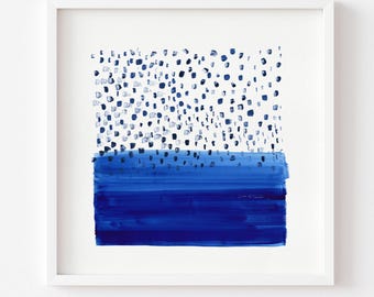 May include: A square art print featuring a blue and white abstract design. The top section displays scattered dark blue brushstroke dots, while the bottom section consists of a solid, horizontal block of deep blue paint. The text reads: Print comes Unframed (no frame or matt included).