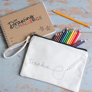 Drawing challenge sketch book with 52 prompts. Comes in a personalised canvas pouch and a set of coloured pencils