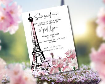 May include: A white invitation card with the Eiffel Tower in black and pink, and the text "She said oui!" announcing a bridal shower for April Lynn on August 21st, 2025. Floral watercolor design at the bottom.