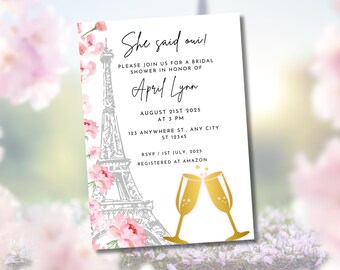 May include: Bridal shower invitation with the text "She said oui!" featuring a gray Eiffel Tower illustration, pink floral accents, and gold champagne glasses. The invitation includes event details for April Lynn.