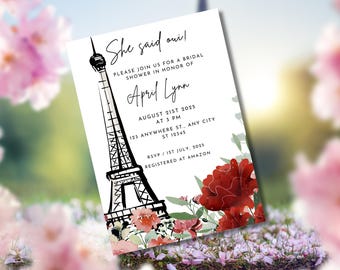May include: Bridal shower invitation with a black and white Eiffel Tower illustration and red floral accents. The invitation reads "She said oui!" and includes event details: August 21st, 2025, at 3 PM, and RSVP by July 1st, 2025.
