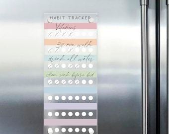 May include: A rectangular magnetic habit tracker board with a clear acrylic surface featuring horizontal pastel-colored stripes. The text HABIT TRACKER is printed at the top, followed by rows of white circles for tracking tasks like Vitamins, 30 min walk, drink all water, and clean sink before bed.