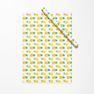 May include: White wrapping paper with a repeating pattern of yellow and green watercolor pineapples. A rolled-up section of the same paper is positioned diagonally across the top of the sheet.