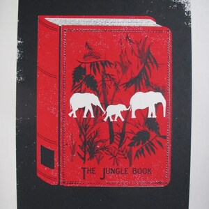 May include: A red book with a black and white illustration of elephants and jungle foliage. The title of the book is "The Jungle Book".