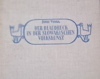 May include: A white book with a blue title on the cover. The title reads "Josef Vydra Der Blaudruck in der Slowakischen Volkskunst".
