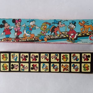 May include: A vintage Disney game with a box featuring Mickey Mouse, Minnie Mouse, Donald Duck, Goofy, Pluto, and other characters. The game includes 16 tiles with different Disney characters.