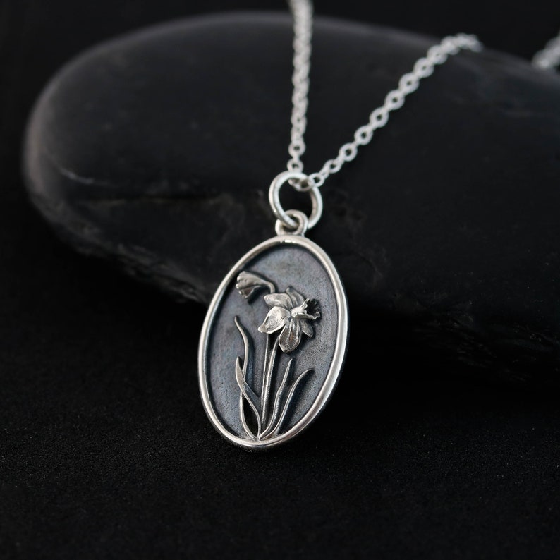 a silver necklace with a flower on it