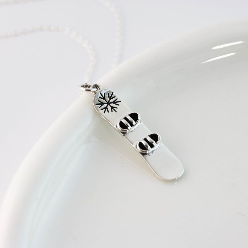 a white plate topped with a silver pendant
