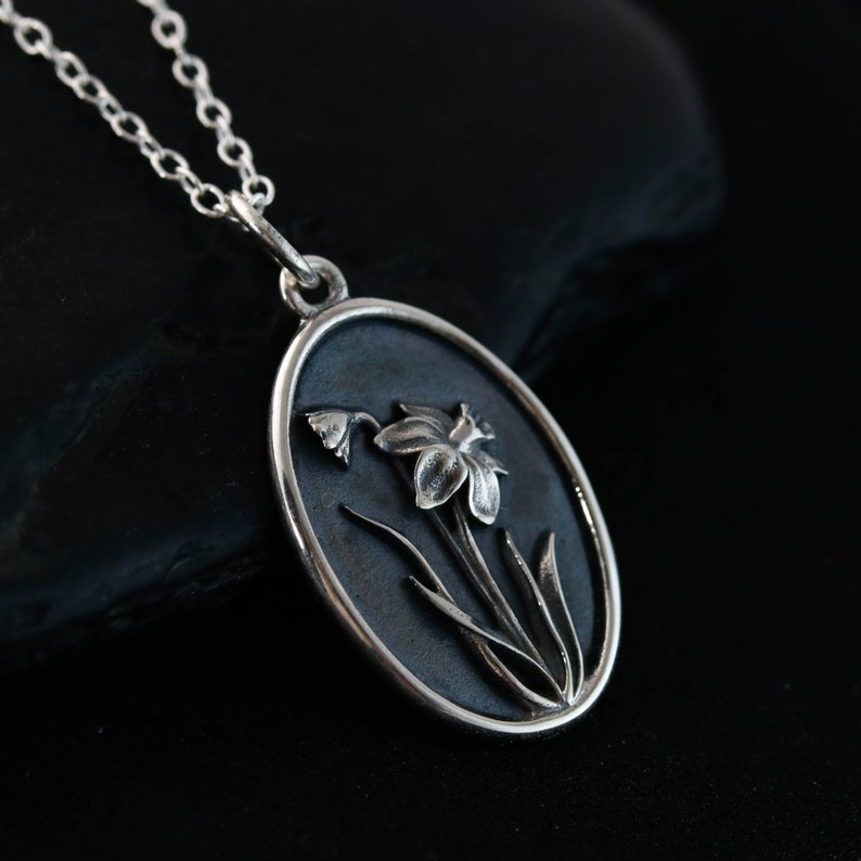 a silver necklace with a flower inside of it