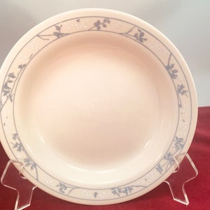 Op de afbeelding: Een wit keramiek dinerbord met een blauw en wit bloemenpatroon rond de rand.