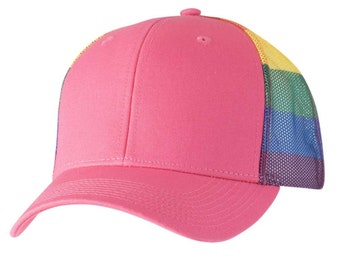 Può includere: Un cappello da camionista rosa con un pannello posteriore in rete arcobaleno. Il cappello ha una visiera curva e una corona strutturata.