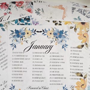 May include: A collection of floral-themed calendar pages, each featuring a month's name and corresponding Bible verses. The pages are adorned with watercolor floral designs in various colors, including blue, pink, and yellow.