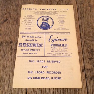 May include: A vintage programme for the Barking Football Club, featuring a crest with a castle and three arrows. The programme advertises Taylor Walker's Reserve Pale Ale and Epicure Piccalilli.