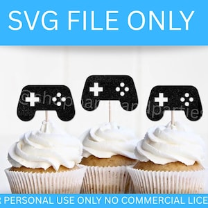May include: Three cupcakes topped with black glittery video game controller decorations. The cupcakes have white frosting and are in paper liners. The text "SVG FILE ONLY" and "FOR PERSONAL USE ONLY NO COMMERCIAL LICENSE" are in the image.