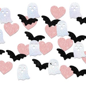 May include: A collection of Halloween-themed glittery cutouts. The image features pink hearts, white ghosts with cut-out eyes, and black bats. The shapes are scattered across a white background, creating a festive and playful design.