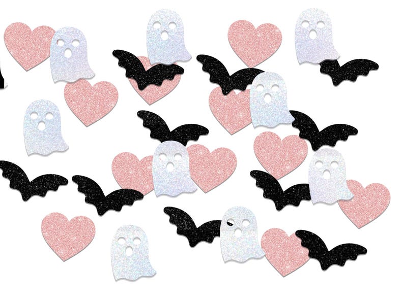 May include: A collection of Halloween-themed glittery cutouts. The image features pink hearts, white ghosts with cut-out eyes, and black bats. The shapes are scattered across a white background, creating a festive and playful design.
