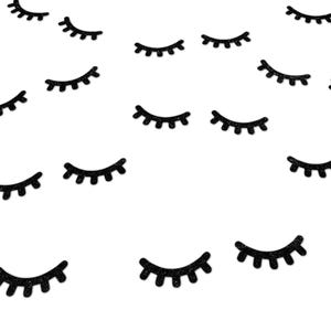 May include: Black glitter eyelash confetti, scattered on a white background.