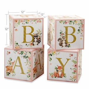May include: Four wooden blocks spelling "BABY", each 12" square. The blocks are white with gold letters, floral accents, and woodland animal illustrations. The edges are trimmed in pink.