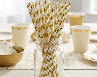 May include: A collection of drinking straws with a metallic gold and white diagonal striped pattern, standing upright inside a clear glass mason jar. The straws are cylindrical and feature a consistent repeating colour design.