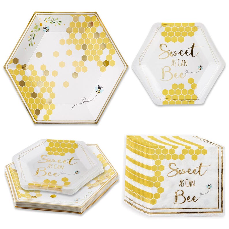 May include: Hexagon-shaped paper plates and napkins with a bee theme. The plates and napkins are white with gold honeycomb patterns and accents. The text "Sweet as can Bee" is printed on the plates and napkins. A stack of napkins is also visible.