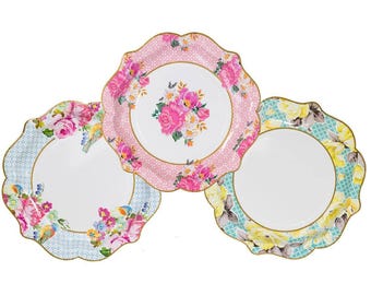 May include: Three decorative paper plates with scalloped edges. One plate is pink with white polka dots and a floral design. Another is light blue with a floral and bird design. The third is turquoise with yellow flowers.
