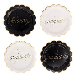 May include: Four graduation-themed paper plates with scalloped edges. Two plates are black with gold text that says "hooray" and "you did it". The other two plates are white with gold text that says "congrats" and "graduate".