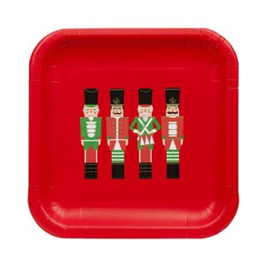 May include: A red square paper plate featuring four toy soldier illustrations in green, red, and white. The toy soldiers are wearing black hats and have mustaches. The plate is perfect for a holiday or Christmas party.