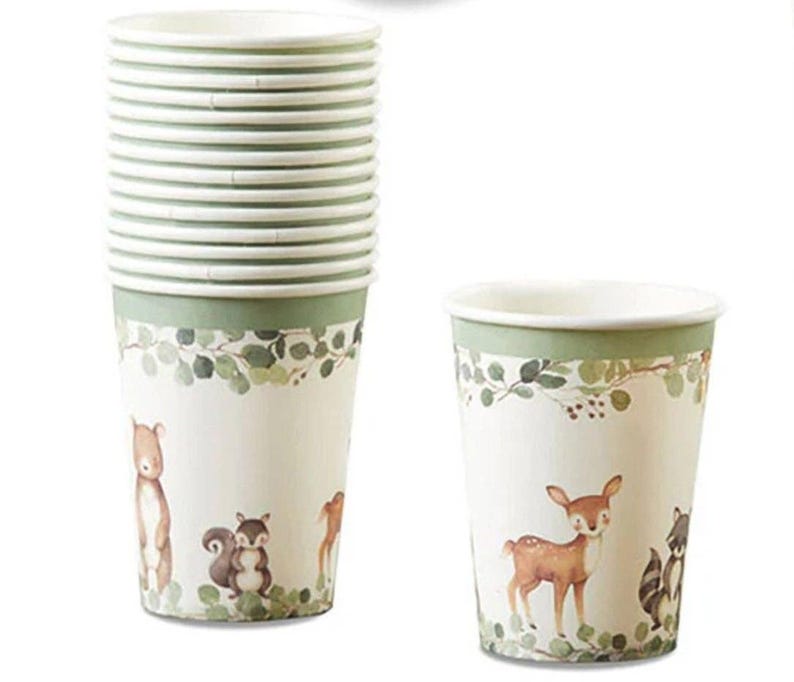 May include: A stack of paper cups with a woodland animal theme. The cups are white with a green band at the top and a forest scene featuring a bear, deer, squirrel, and raccoon. The cups are designed for beverages.