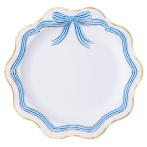 May include: White paper plate with a scalloped edge and a gold trim. The plate features a blue bow and blue striped border design. A decorative plate for serving food.