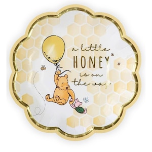 May include: A decorative paper plate with a scalloped edge and a gold border. The plate features a yellow balloon, Winnie the Pooh, Piglet, and the text "a little HONEY is on the way."