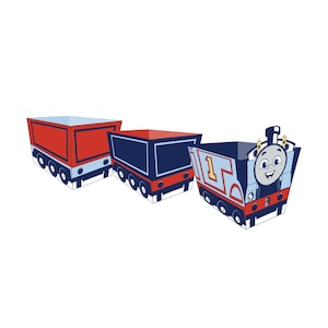 May include: Three open-top paper containers designed to look like train cars. One container features the face of a blue locomotive with the number 1, while the other two are red and blue cargo cars. All pieces have black wheels along the base.