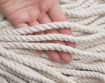 May include: A close-up of a white cotton rope with a diameter of 8mm and a length of 10 yards (9 metres). The rope is shown in a pile with a hand holding a few strands.