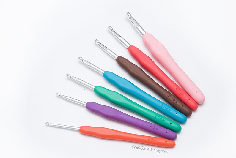 May include: A set of seven colorful crochet hooks with different sizes, ranging from 3.0 mm to 6.0 mm. The hooks are made of metal with plastic handles.