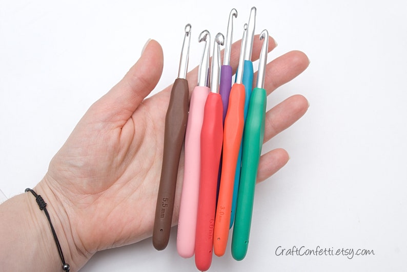 May include: A set of six colorful crochet hooks with ergonomic handles. The hooks are arranged in a fan shape and are labeled with their sizes in millimeters: 5.5 mm, 5.0 mm, 4.5 mm, 4.0 mm, 3.5 mm, and 3.0 mm.