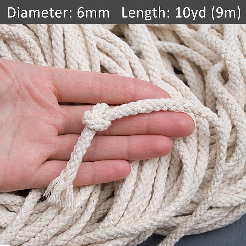 May include: A close-up of a 6mm thick, natural cotton rope. The rope is braided and has a natural white colour. The rope is 10 yards (9 metres) long.