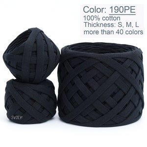 Könnte beinhalten: Drei schwarze Baumwollgarn-Knäuel, ein großes und zwei kleinere, mit einer gewebten Textur. Das Garn ist 100% Baumwolle und in über 40 Farben erhältlich. Das Garn ist mit "190PE" gekennzeichnet.